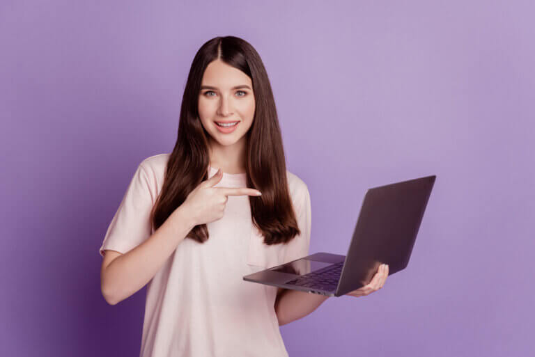 Photo of girl with laptop direct finger device on purple background